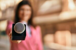 Middle,Age,Reporter,Woman,Holding,Journalist,Mic,Close,To,The