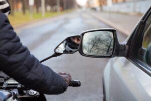 Motorcycle,Rider,Touching,Side,Mirror,Of,A,Car,When,Riding